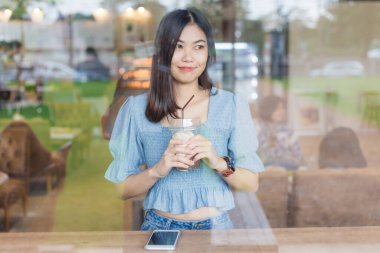 Kahve dükkanında buzlu kahve içen güzel kadınlar.