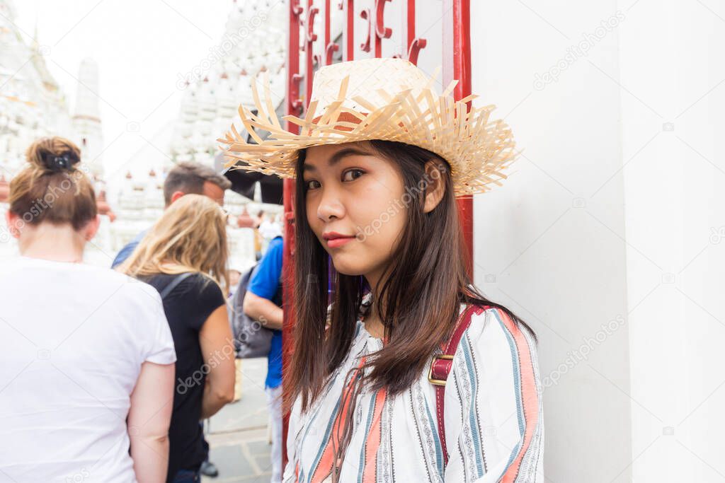 Women wear summer hat walking to travel in temple of dawn Wat Arun Bangkok Thailand