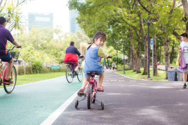 Şehir parkında bisikletli küçük bir kız.