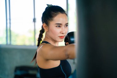 Boksör kadınlar boks stüdyosunda torba yumrukluyor. Asyalı kadın savunma egzersizi