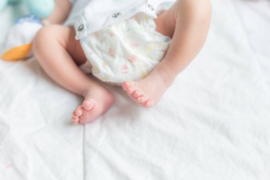 Yatakta uzanmış şirin küçük bebek Yeni doğmuş bebek ayakları beyaz battaniyenin üzerinde