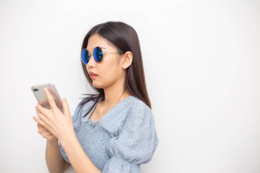 Güzel moda Asyalı güneş gözlükleri kadınlar beyaz arka planda akıllı telefon kullanır
