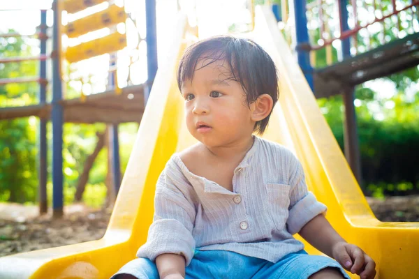 Anaokulundaki çocuk oyun parkında sürgülü oyun oynuyor.