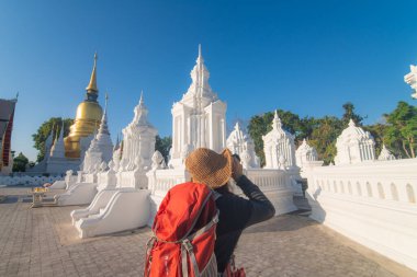 Mutlu Asyalı turist sırt çantalı kadınlar altın pagoda geçmişi olan Chiangmai tapınağına seyahat eder.