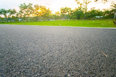 Şehir parkında asfalt yürüyüş ve koşu yolu akşam vakti doğa manzarası