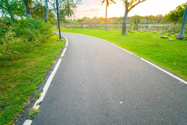 Şehir parkında asfalt yürüyüş ve koşu yolu akşam vakti doğa manzarası