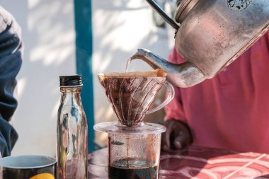 Evdeki sabah masasında filtrelenmiş kahve demlemek.