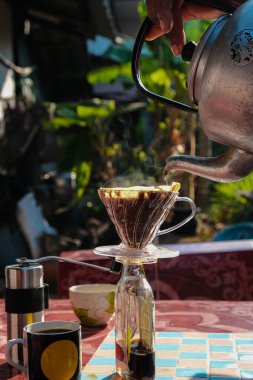Evdeki sabah masasında filtrelenmiş kahve demlemek.