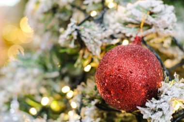 Yılbaşı ağacındaki renkli topları kapatın. Arka planda Bokeh çelenkleri var. Yeni yıl konsepti.