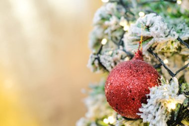 Kırmızı lüks noel balosu. Pinne ağacına asılmış. Arka planda bokeh.