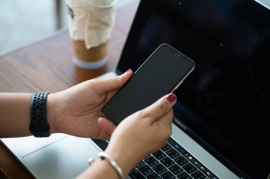 Kadınlar masa başı iş bağlantılarında dizüstü bilgisayarı olan akıllı telefon kullanırlar