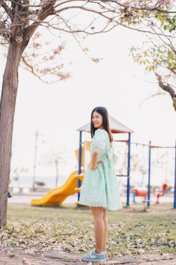 Sonbahar parkında pembe sakura çiçekli güzel kadınlar gün batımında.