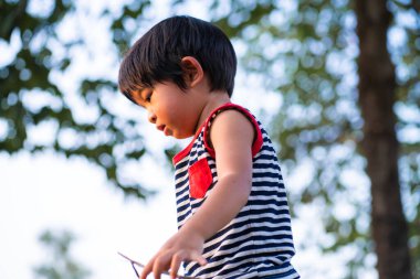 Yeşil doğa parkında oynayan çocuk gün batımı açık hava aktivitesi