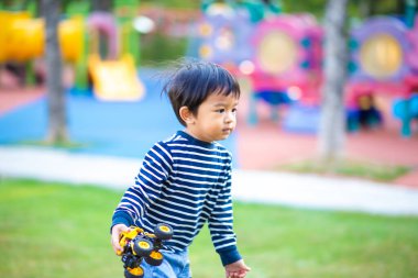Sabahleyin yeşil çimlerde koşan sevimli küçük çocuk parkın güneş doğuşu egzersizi