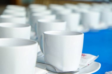 Kahve fincanı sehpanın üzerinde kavanozdan kahve dökülüyor.