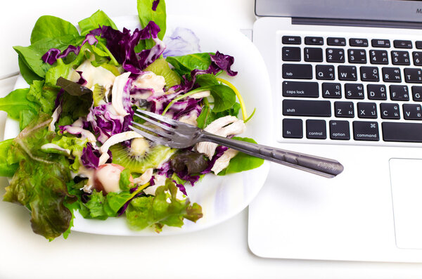 Many color salad with business laptop isolated on white 
