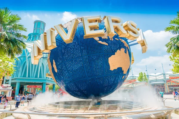 Tourists and theme park visitors taking pictures of the large rotating globe fountain in front of Universal Studios — Stock Photo, Image