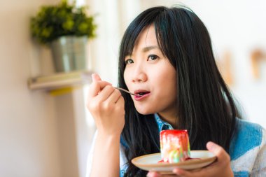 Asyalı kadın Çilekli pasta ekmek kafede yemek gülümseyen
