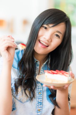 Asyalı kadın Çilekli pasta ekmek kafede yemek gülümseyen