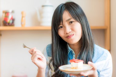 Asyalı kadın Çilekli pasta ekmek kafede yemek gülümseyen