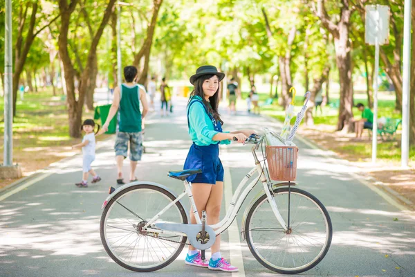 Азиатская молодая женщина с велосипедом в летнем парке . — стоковое фото