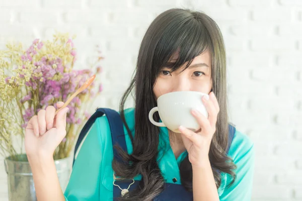 Beautiful young asian woman with a cup of tea at a cafe — Stock Photo, Image