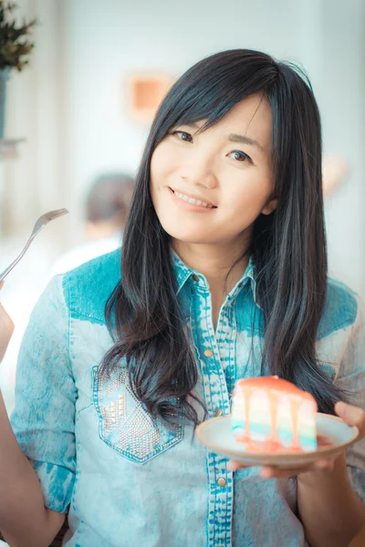 Portrait of young asian pretty smiling woman eating cake at cafe — Stock Photo, Image