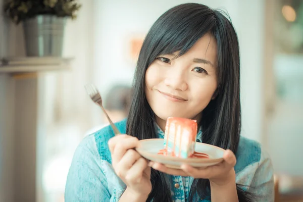 Portrait of young asian pretty smiling woman eating cake at cafe — Stock Photo, Image