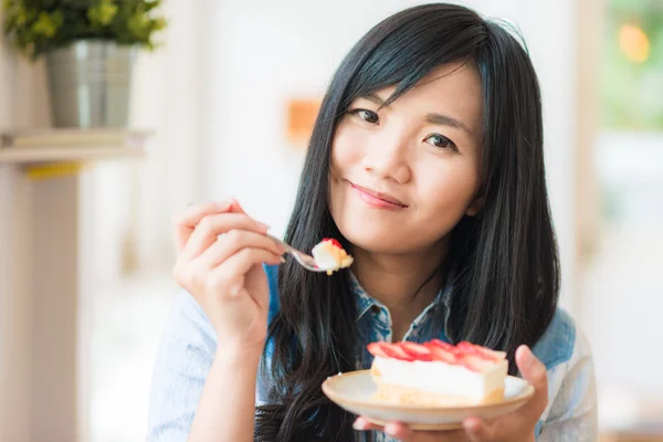 Portrait of young asian pretty smiling woman eating cake at cafe — Stock Photo, Image