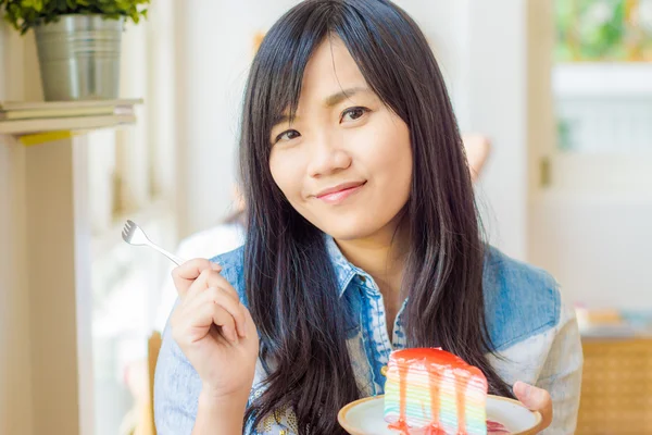 케이크를 먹는 아름 다운 웃는 젊은 아시아 여자 — 스톡 사진