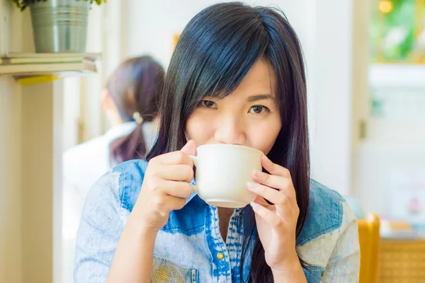 Mujer con taza de café sonriendo en la cafetería —  Fotos de Stock