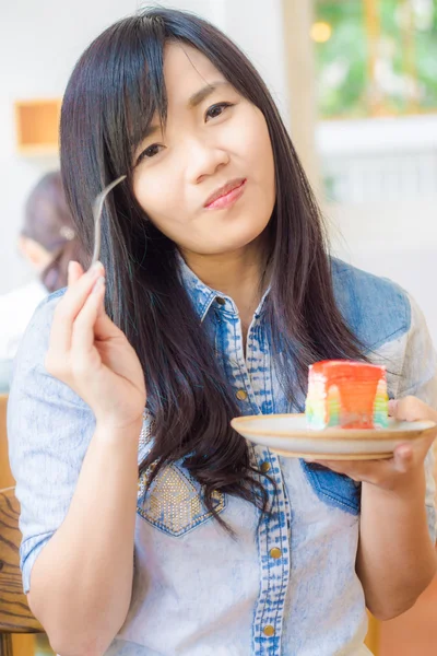 亚洲微笑的女人，穿着咬这块美味的吉恩衬衫 — 图库照片