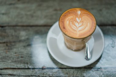 Latte üzerinde eski ahşap masa kahve fincan