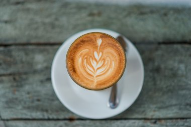 Latte üzerinde eski ahşap masa kahve fincan