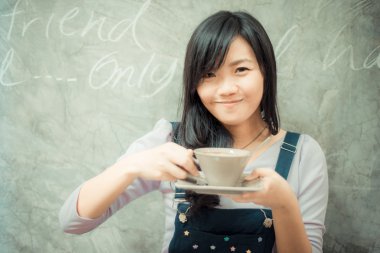 Kafede kahve fincanı tutan iş Asyalı kadın