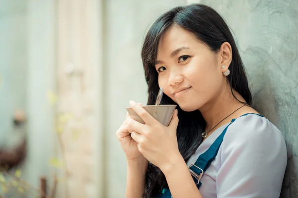 Hermosa asiático joven mujer con café taza buscando a cámara en —  Fotos de Stock