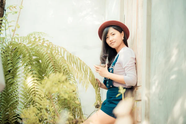 Beautiful asian young woman with coffee cup looking to camera at — Stock Photo, Image