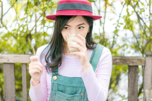 Gyönyörű fiatal ázsiai lány, szabadtéri kávézóban kávét iszik. — Stock Fotó