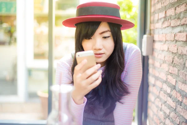 Азиатка с помощью смартфона в кофейне утром — стоковое фото