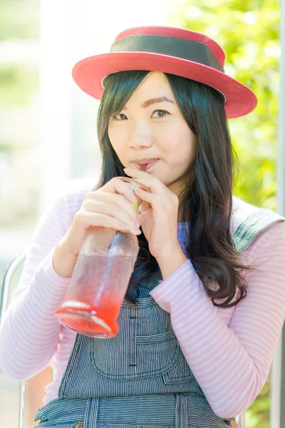 Азиатка пьет клубничный лимонад в кафе — стоковое фото