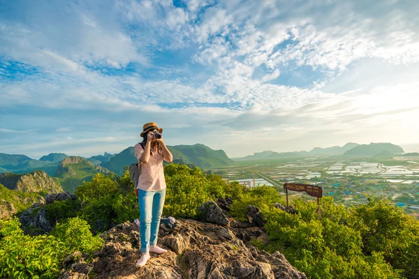 Hiker woman with camera enjoy the view at sunrise mountain peak — Stock Photo, Image