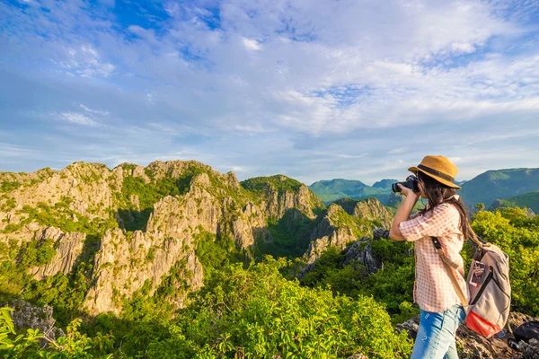 Hiker woman with camera enjoy the view at sunrise mountain peak — Stock Photo, Image