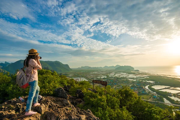 Caminante mujer con cámara disfrutar de la vista al amanecer pico de la montaña — Foto de Stock