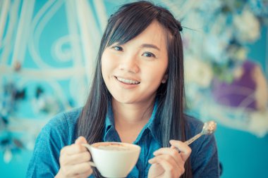 Kafede kahve içme genç Asyalı kadın 