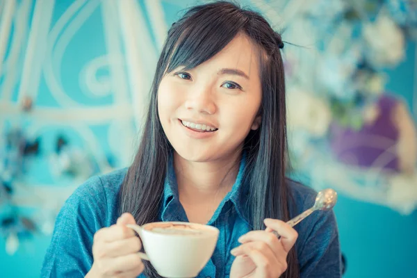 Νεαρή γυναίκα της Ασίας πίνοντας τον καφέ στην καφετέρια — Φωτογραφία Αρχείου