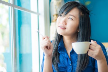 Kafede kahve içme genç Asyalı kadın 