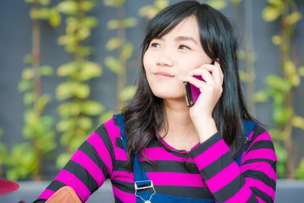 Beautiful asian young woman speaking by mobile phone Royalty Free Stock Photos