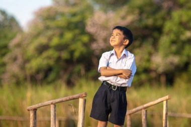 Asyalı okul çocuğu, şehir parkında rahatla, gün batımı, gün batımı, şehir çocuğu.