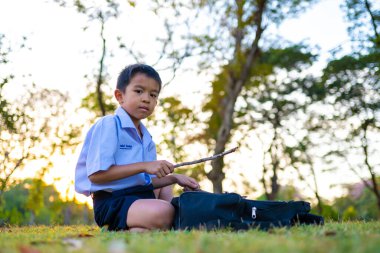 Asyalı okul çocuğu, şehir parkında rahatla, gün batımı, gün batımı, şehir çocuğu.