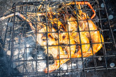 Büyük nehir karidesi ateşte kızartılmış deniz mahsulü yemeğiyle.